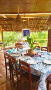 a dining table with chairs and a blue and white table cloth at Paruparong Bughaw Ecofarm Resort in Quezon