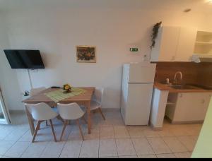 a kitchen with a table and a white refrigerator at APARTMAN 1 KRISTINKA Gujinović in Gradac +10 photos