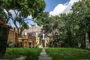 4 bedroom home - N17 في لندن: a woman walking down a path in a garden