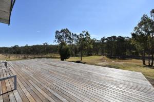 a large wooden deck with a view of a field at The Parsons Retreat in Rothbury