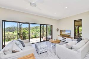 a living room with white furniture and large windows at Kookaburra Range in Greta