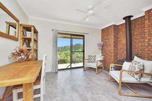 a living room with a brick wall and a table and chairs at Kookaburra Range in Greta +26 photos