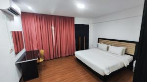 a bedroom with a white bed and a red curtain at Likas Square - KK Spacious Homestay in Kota Kinabalu +12 photos
