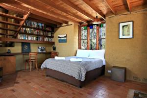 a bedroom with a bed and a book shelf at Corymbia Cottage Brokes Secluded Escape for max 4 in Broke