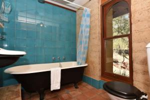 a bathroom with a tub and a toilet and a sink at Corymbia Cottage Brokes Secluded Escape for max 4 in Broke