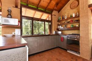 a kitchen with stainless steel appliances and a large window at Corymbia Cottage Brokes Secluded Escape for max 4 in Broke +16 photos