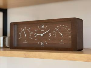 a clock sitting on top of a wooden shelf at Obaranchi - Vacation STAY 18154 in Kawasaki