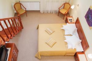 an overhead view of a bedroom with a bed and chairs at Pensiunea Noel in Băile Olăneşti