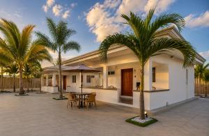 a house with a patio with a table and palm trees at Beyond Island Resort in Moalboal