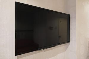 a flat screen tv hanging on a wall at R Hotel - Vacation STAY 19199 in Chiba +13 photos