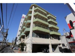 a tall building with a parking lot in front of it at R Hotel - Vacation STAY 19199 in Chiba