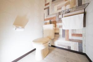 a bathroom with a toilet and a wooden wall at R Hotel - Vacation STAY 19198 in Chiba