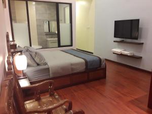 a bedroom with a bed with a mirror and a tv at De Benz Inn in Malacca