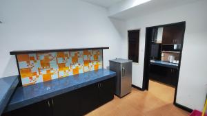 a kitchen with a counter top and a refrigerator at Likas Square - KK Spacious Homestay in Kota Kinabalu