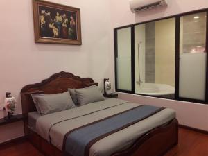 a bedroom with a bed and a large window with a bath tub at De Benz Inn in Malacca