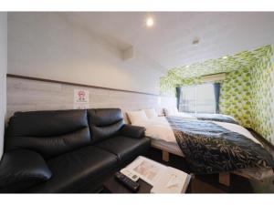a living room with a couch and a bed at R Hotel - Vacation STAY 19689 in Chiba +11 photos