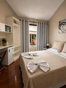 a bedroom with a bed with a bow on it at Pousada Casa Da Praia in Florianópolis +31 photos