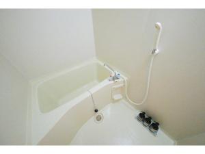 a white bath tub with a shower in a bathroom at R Hotel - Vacation STAY 19692 in Chiba