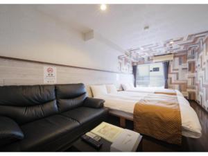 a living room with a couch and a bed at R Hotel - Vacation STAY 19692 in Chiba