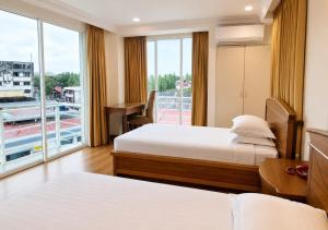 a hotel room with two beds and a balcony at Kudat Ria Hotel Plt in Kudat