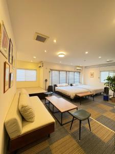 a room with two beds and a couch and tables at Frontier First Building - Vacation STAY 19759 in Kagoshima