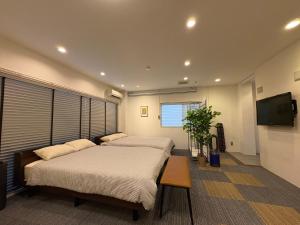 a bedroom with two beds and a flat screen tv at Frontier First Building - Vacation STAY 19759 in Kagoshima
