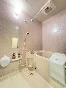 a bathroom with a tub and a toilet and a sink at Frontier First Building - Vacation STAY 19759 in Kagoshima +47 photos
