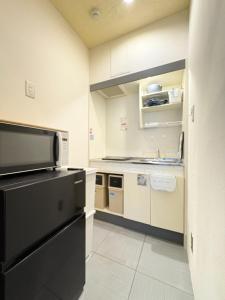 a kitchen with a black refrigerator and a sink at Frontier First Building - Vacation STAY 19759 in Kagoshima