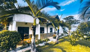 a house with palm trees in front of it at Dumaguete Dive Center in Mojon