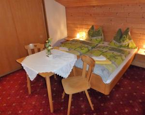 a bedroom with a bed and a table and chairs at Haus Lärchenheim in Wagrain