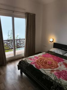 a bedroom with a bed and a large window at Kodai Cloud Villa in Kodaikānāl
