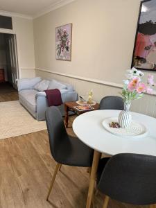 a living room with a table and a couch at Fitzroy Cottage one bedroom CBD accommodation in Tamworth