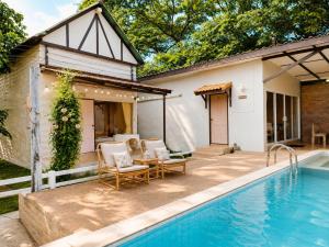 a patio with a pool and chairs next to a house at The Scarecrow House in Ban Doem Bang (1) +36 photos