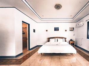 a bedroom with a bed in a white room at Dumaguete Dive Center in Mojon