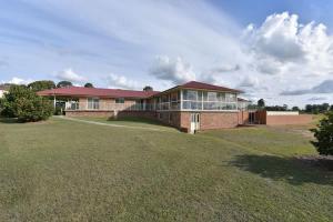 a large brick house with a large yard at Noble Willow Studio Lovedale. A Cosy Unique Wine Country Refuge in Lovedale