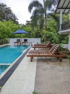 a group of benches sitting next to a swimming pool at Finch Tangalle in Tangalle