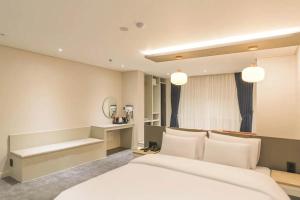 a bedroom with a large white bed and a desk at 주노 호텔 in Tujŏng-dong +25 photos