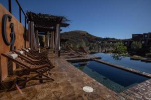 a group of chairs sitting next to a swimming pool at o2 Resort Valle de Guadalupe in Valle de Guadalupe