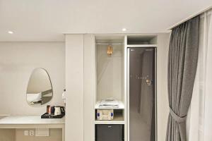 a white bathroom with a mirror and a sink at 주노 호텔 in Tujŏng-dong
