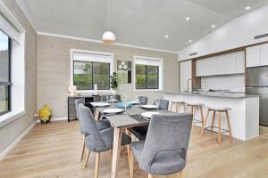 a kitchen and dining room with a table and chairs at Somerville Wines Lux Escape 3-Bedroom Cottage Near Broke Wineries in Broke