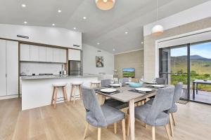 a kitchen and dining room with a table and chairs at Somerville Wines Lux Escape 3-Bedroom Cottage Near Broke Wineries in Broke