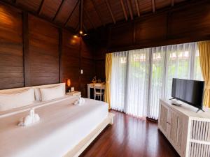 a bedroom with two beds and a flat screen tv at Kayangan Villa Ubud in Ubud +46 photos