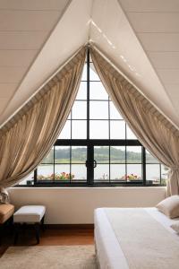 a bedroom with a large window and a bed at Royal Lake Hotel in Nuwara Eliya