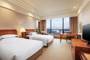 a hotel room with two beds and a flat screen tv at Hilton Chongqing in Chongqing
