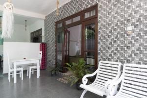 a living room with two white chairs and a table at The Canapy Nest Ella in Ella