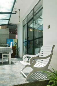 two white benches sitting in front of a building at The Canapy Nest Ella in Ella