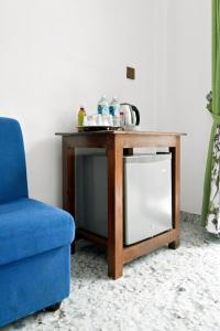 a table with a tv and a blue chair at The Canapy Nest Ella in Ella