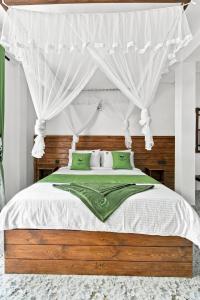 a bedroom with a canopy bed with green pillows at The Canapy Nest Ella in Ella +26 photos