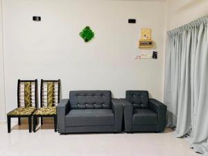 a living room with a couch and two chairs at Chendering Beach Stay in Kuala Terengganu