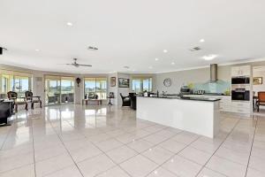 a large kitchen and living room with white tile floors at Noble Willow Estate in Lovedale